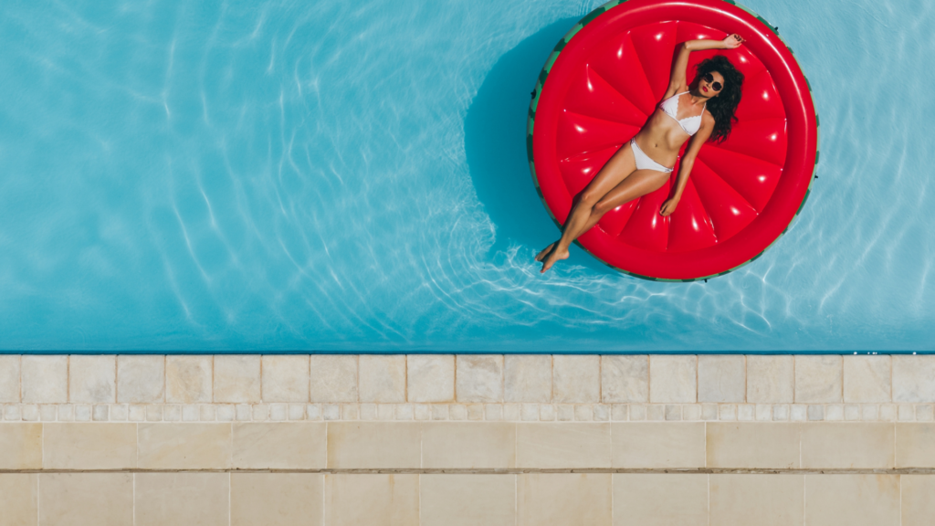 femme sur une bouée rouge dans une piscine creusée bleue